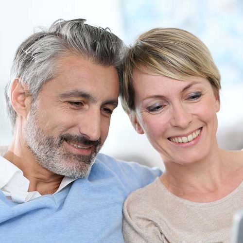 Cheerful mature couple e-shopping on internet